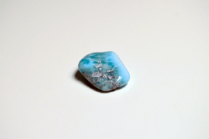 Ein gebänderter Larimar Trommelstein mit blauen & weißen Kristall Arealen.