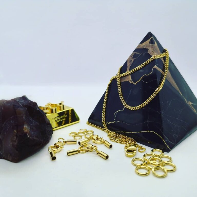 24 Karat vergoldete Schmuckteile mit Marmorpyramide und Goldbarren.