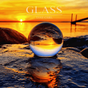 Eine Kristallkugel liegt vor dem Sonnenuntergang im Meer und spiegelt dieses.