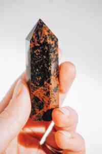 Eine geschliffene Kristallspitze aus braun/schwarz gemustertem Mahagoni-Obsidian.