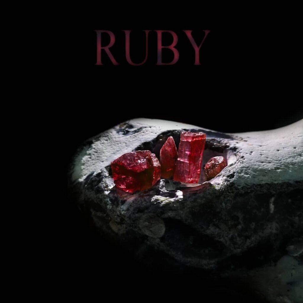 Rubin Edelstein Kristalle auf weißer Matrix mit Überschrift "RUBY"