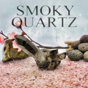 Rauchquarzkristall auf pinkem Grund vor Steinen und Kirschzweig mit blauem Himmel. Die Überschrift zum Rauchquarz lautet "SMOKY QUARTZ"