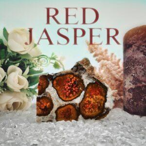 Roter Jaspis Edelstein auf Bergkristallgrund mit Pflanzen im Hintergrund. Die Überschrift des Kraftstein Bildes lauter "RED JASPER".