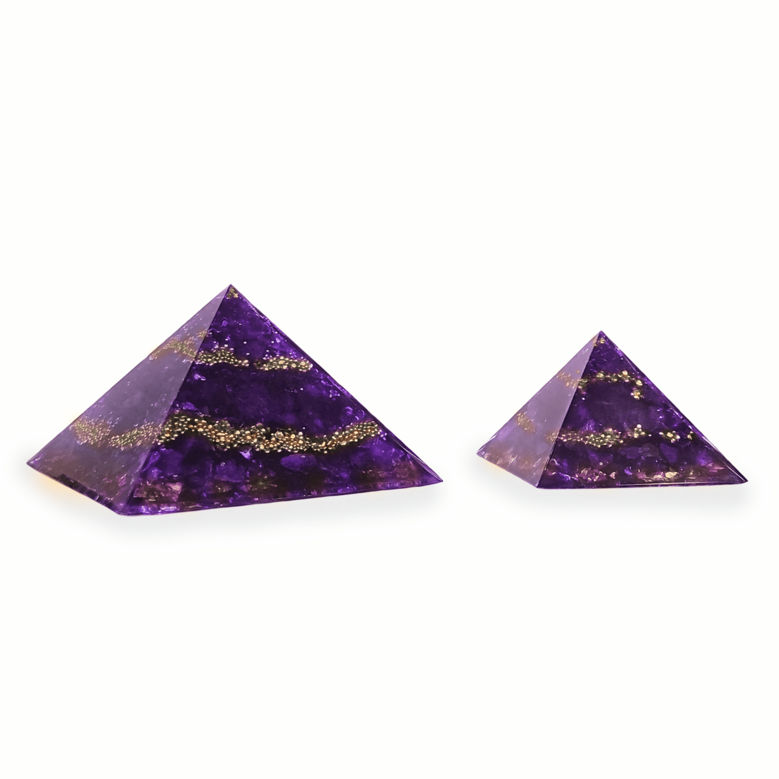 Eine große XXL Orgonit Pyramide, sowie ein mittelgroßer Orgonit mit den Edelsteinen Amethyst, Charoit & Bergkristall. Die Orgoniten sind lila mit goldenen Metallelementen.