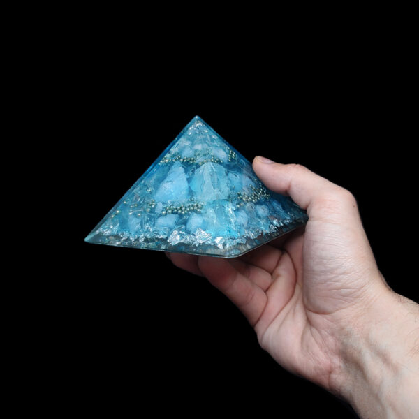 Hellblaue Orgonit Pyramide mit blauen Edelsteinen & silbernem Metall.