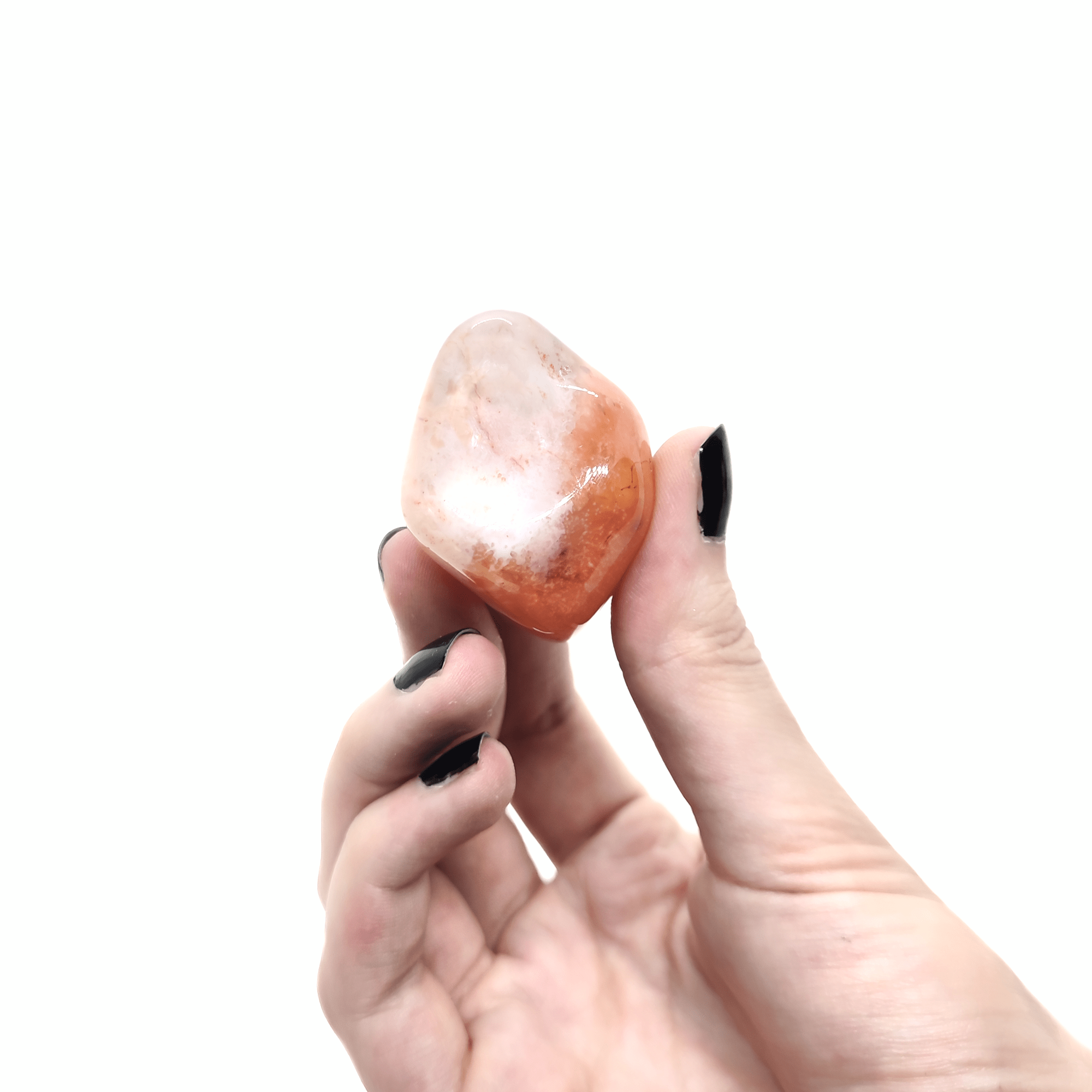 Ein großer Karneol Trommelstein. Dieser Edelstein ist transparent orange & weist kristalline Einschlüsse auf.