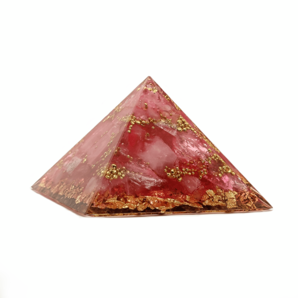 Eine rosa Orgonit Pyramide, welche der Liebe gewidmet ist. Dieser Rosenquarz Kristall weist goldene Elemente auf.