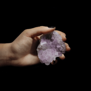 Pinke Amethyst Stufe, welche von einer Frauenhand gehalten wird.