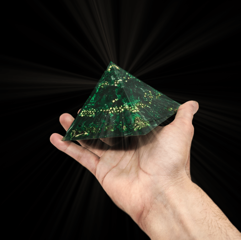 Eine intensiv dunkelgrüne Smaragd Orgonit Pyramide mit goldenen Elementen.