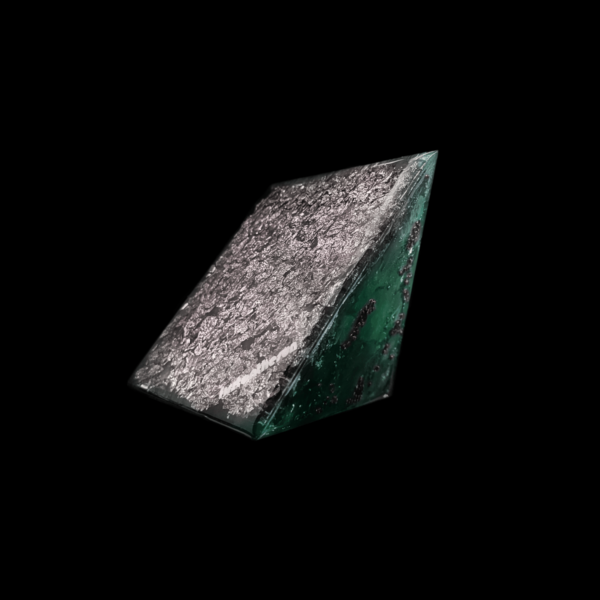 Mit silberflocken versehene Bodenfläche eines Orgonit Energie Kristalls. Dieser ist hellgrün.