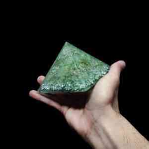 Grüner Energkie Kristall mit Edelsteinen in Form einer Orgonit Pyramide.