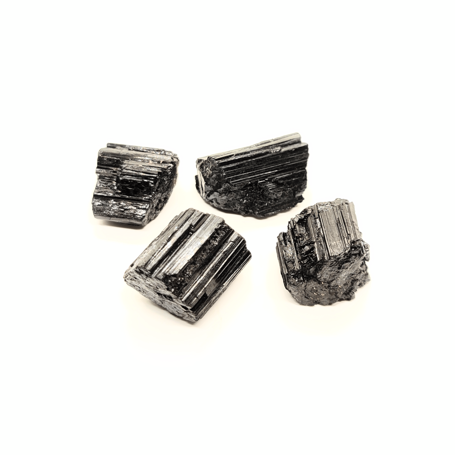 Schwarze Turmalin Rohsteine, welche auch als Schörl bezeichnet werden. Diese Steine sind länglich, rein schwarz & zeigen die typische Turmalin Kristallform auf.