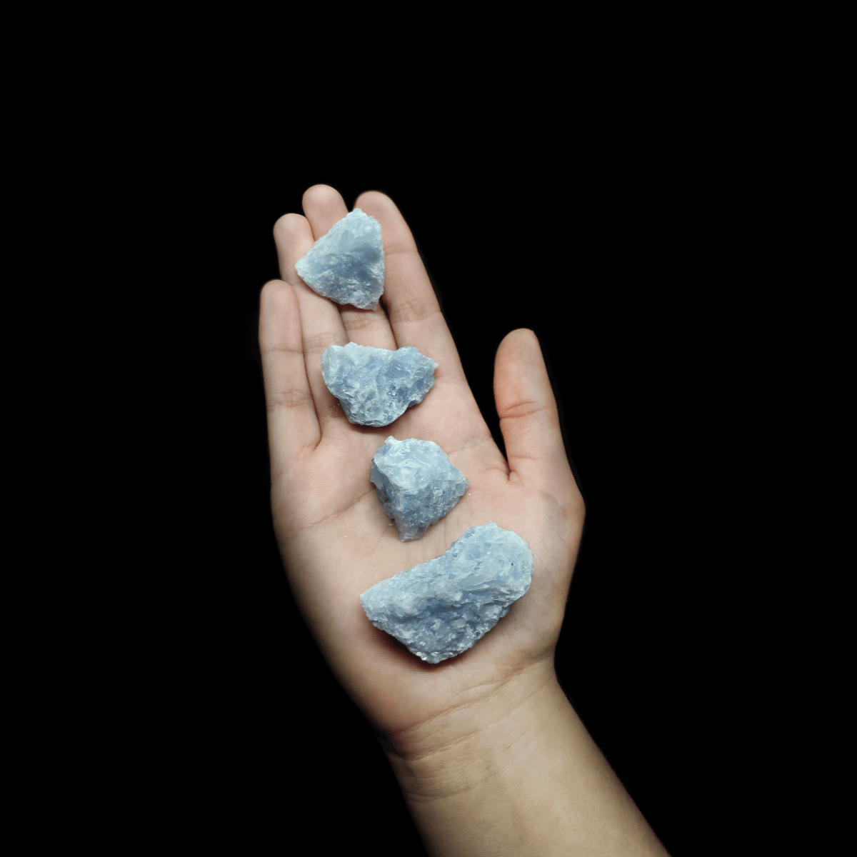 Präsentation von Blauem Calcit Rohstein in unterschiedlichen Größen. Die Kristalle des Edelsteins sind deutlich zu erkennen.