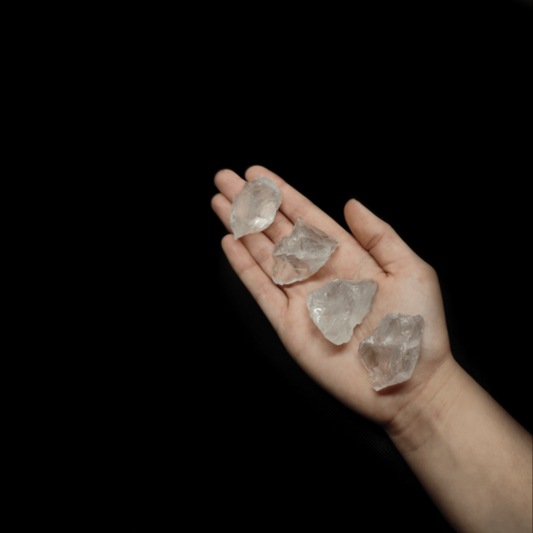 Girasol Rohsteine, welche auf der Handfläche einer Frau liegen. Girasol ist weniger transparenter Bergkristall.