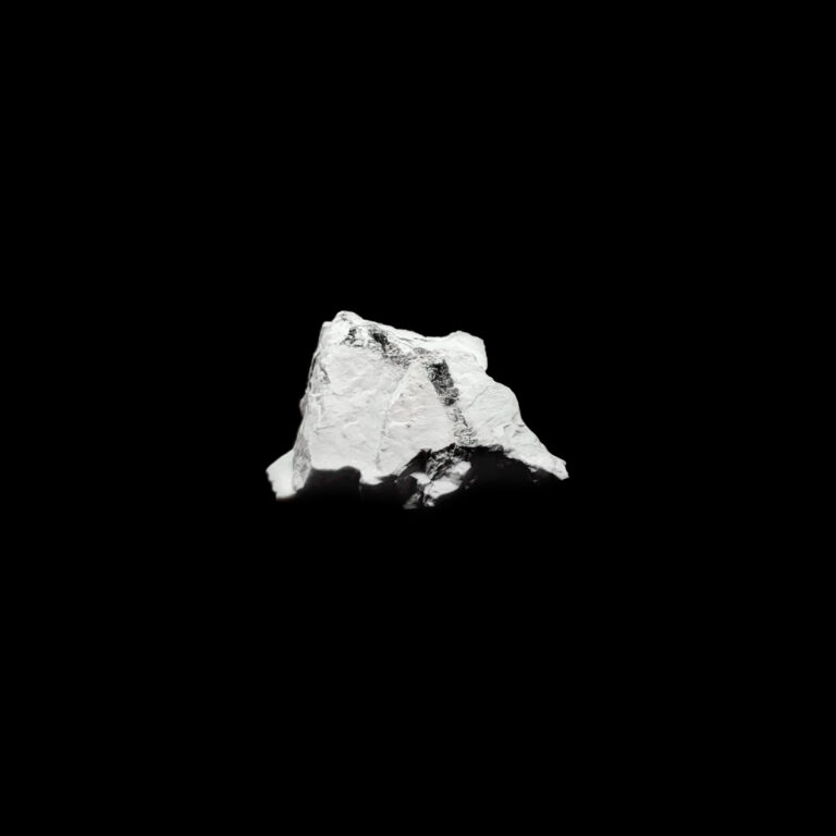 Weißer Magnesit Rohstein mit schwarzen Streifen im Kristall.
