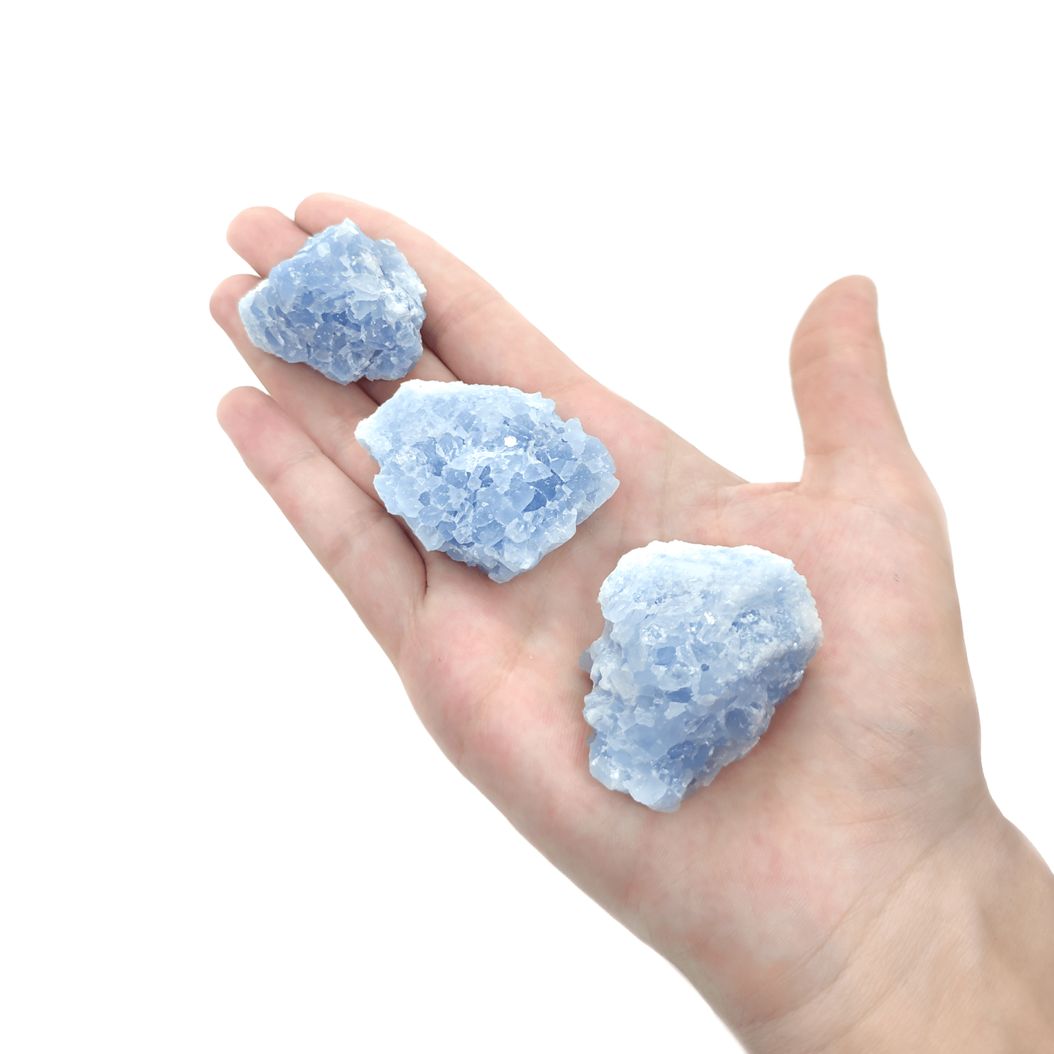 Produktpräsentation von blauen Calcit Steinen. Die Rohsteine weisen ausgeprägte Kristalle auf.