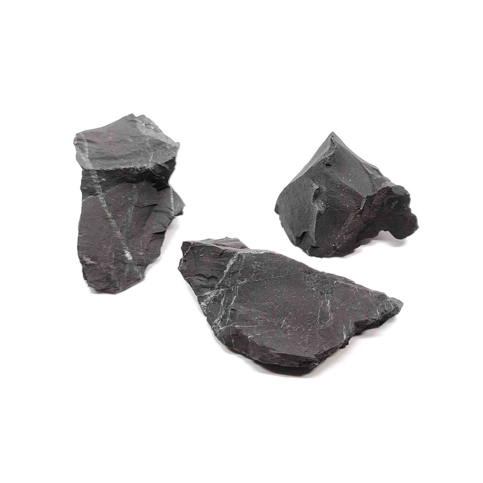 Schwarze Kohlenstoffhaltige Schungit Rohsteine auf weißem Hintergrund. Schungit ist ein dunkles Gestein aus einst fossilen Pflanzenteilen.