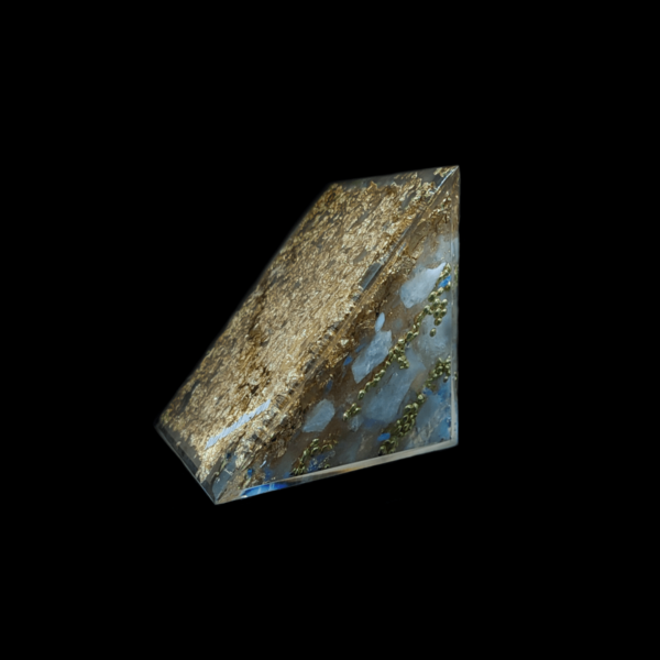 Boden einer Orgonit Pyramide. Neben Goldflocken sind blau schimmernde Steine zu erkennen.
