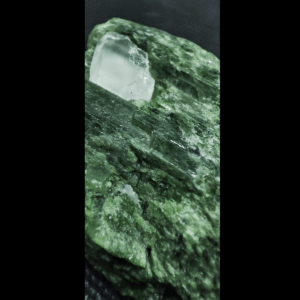 Makro-Aufnahme der Kristalle eines grünen Diopsid Rohsteins.