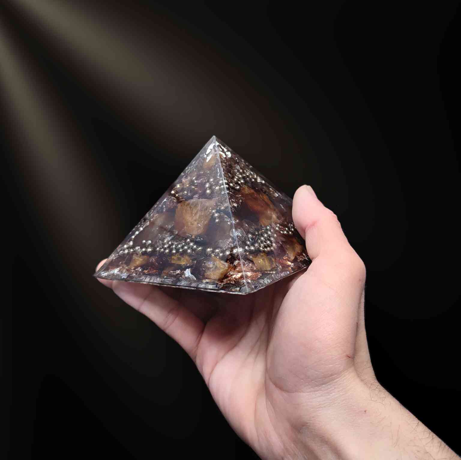 Braun & silberfarbene Orgonit Pyramide mittlerer Größe mit Edelsteinen.