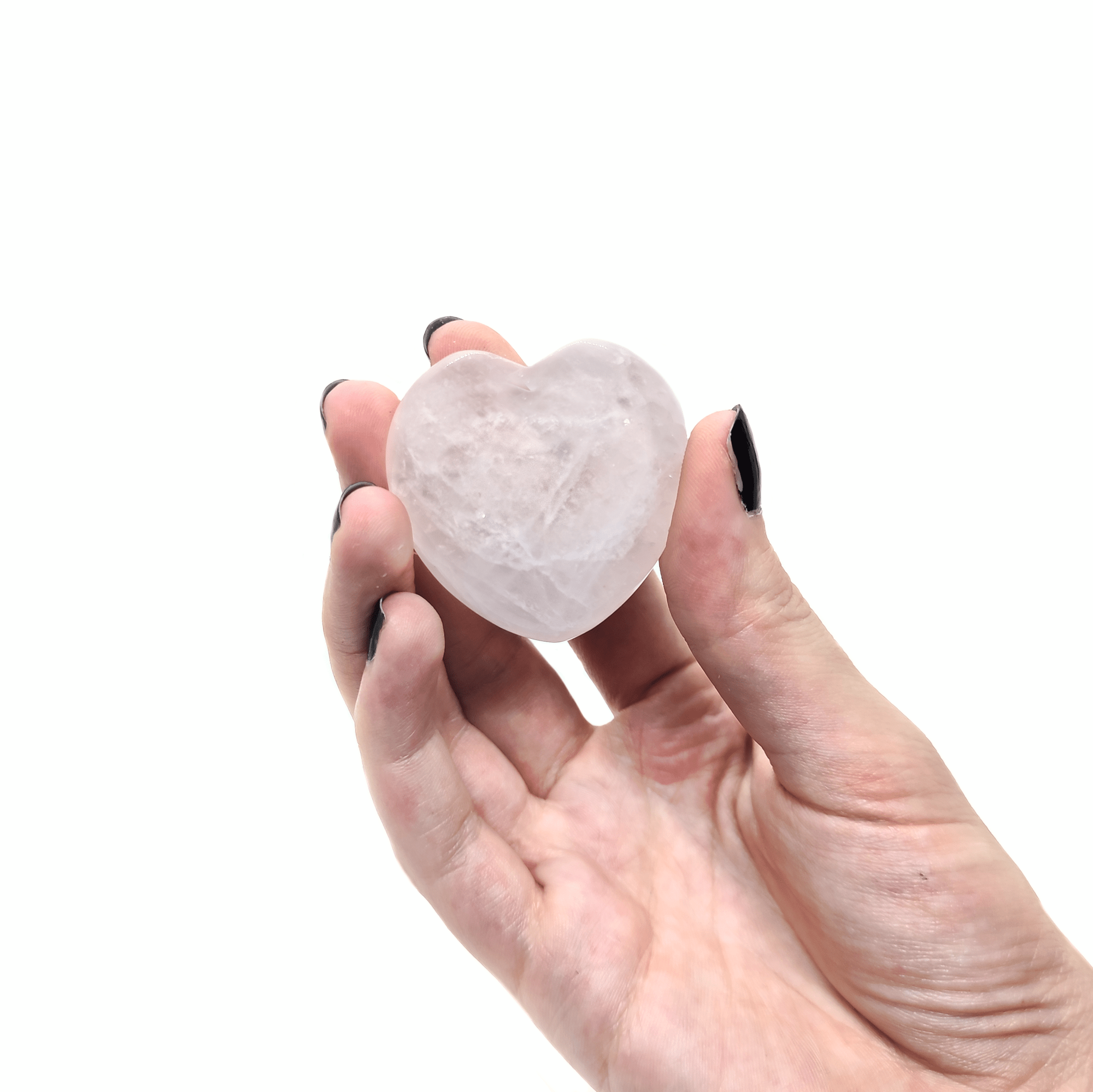 Herzförmiger Rosenquarz welcher von einer Frauenhand gehalten wird.