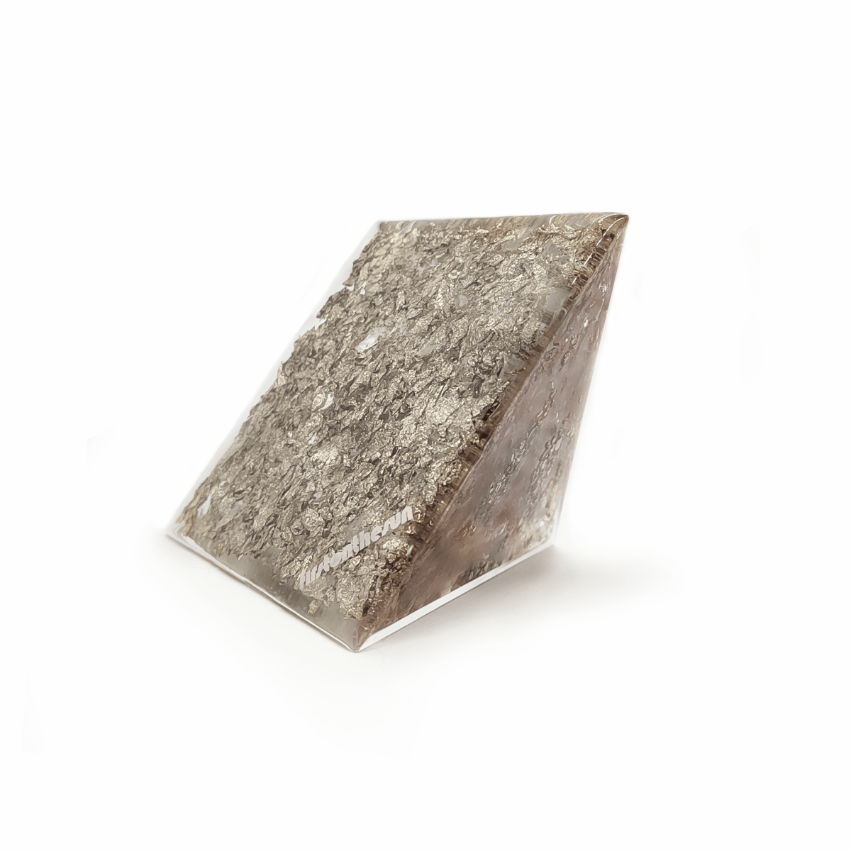 Bodenfläche eines firstonthesun Orgoniten. Die Unterseite dieser hellbraunen Orgonit Pyramide weist silberne Metallic Elemente auf.