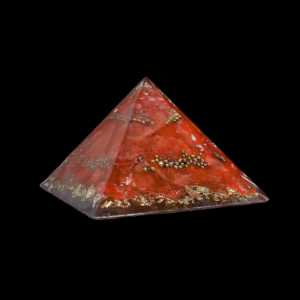 Rote Orgonit Pyramide mit goldenen Elementen. Dieser Kristall der Flamme ist ein Edelstein Produkt nach der Orgonit Bauweise.