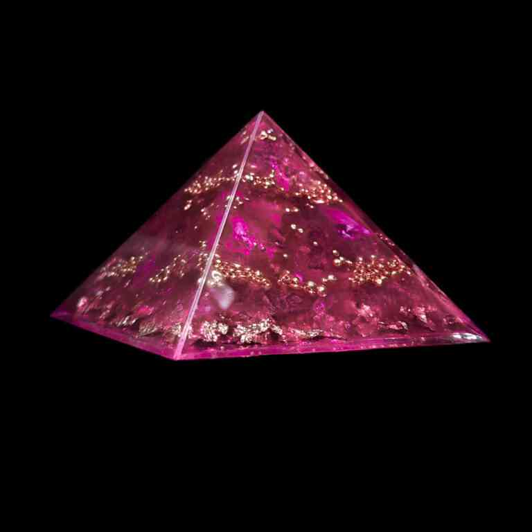 Produktbild der Feenkristall Orgonit Pyramide mit den Edelsteinen pinker Saphir, Herkimer Diamant & Bergkristall. Dieser pinke Orgonit weist zudem goldene Metallelemente auf.