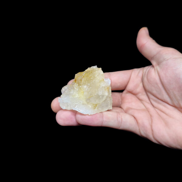 Heller Citrin Kristall "Lemon Quartz" Rohstein auf einer Handfläche.