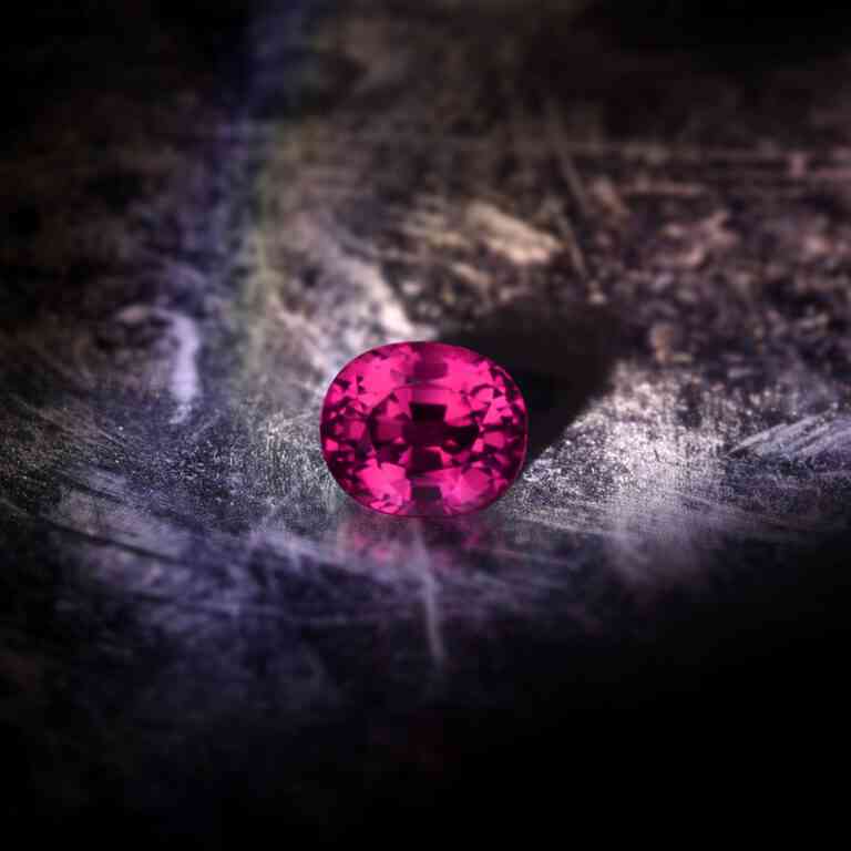 Violett-Roter Spinell Kristall mit leuchtenden Facetten.