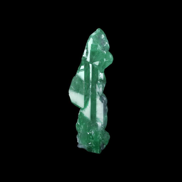 Ein roher Alexandrit Kristall, welcher sowohl grüne, als auch violette Areale aufweist.