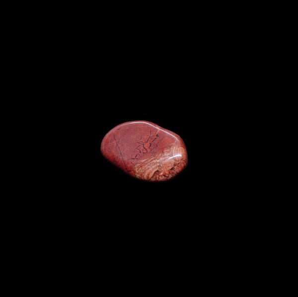 Ein roter Jaspis Trommelstein. Der Jaspis Kristall hat Bänderungen.