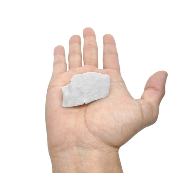 Weißer kristalliner Baryt zur Produktpräsentation auf einer Hand.