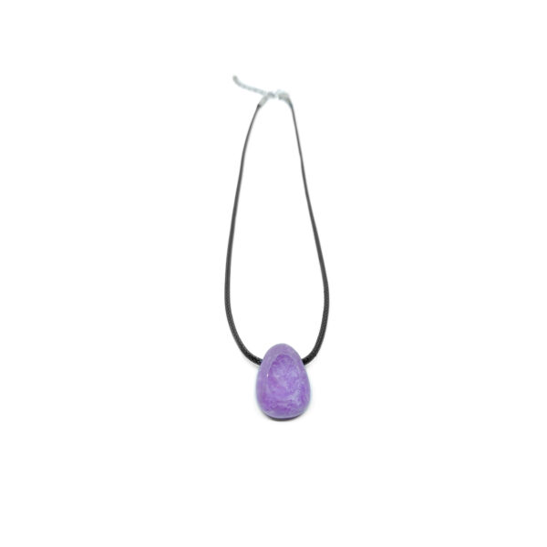 Ein violetter Lepidolith Kristall in Tropfenform mit Halskette. Das Schmuckband des polierten Edelsteins ist Schwarz.