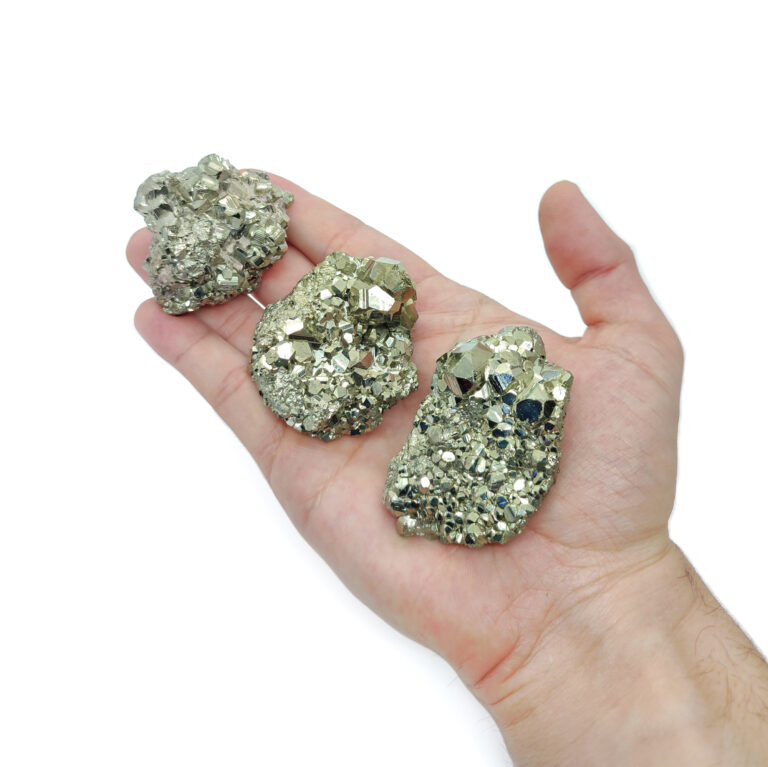 Silber-golden glänzende Pyrit Kristallstufen, welche zur Größenansicht auf einer Hand liegen.